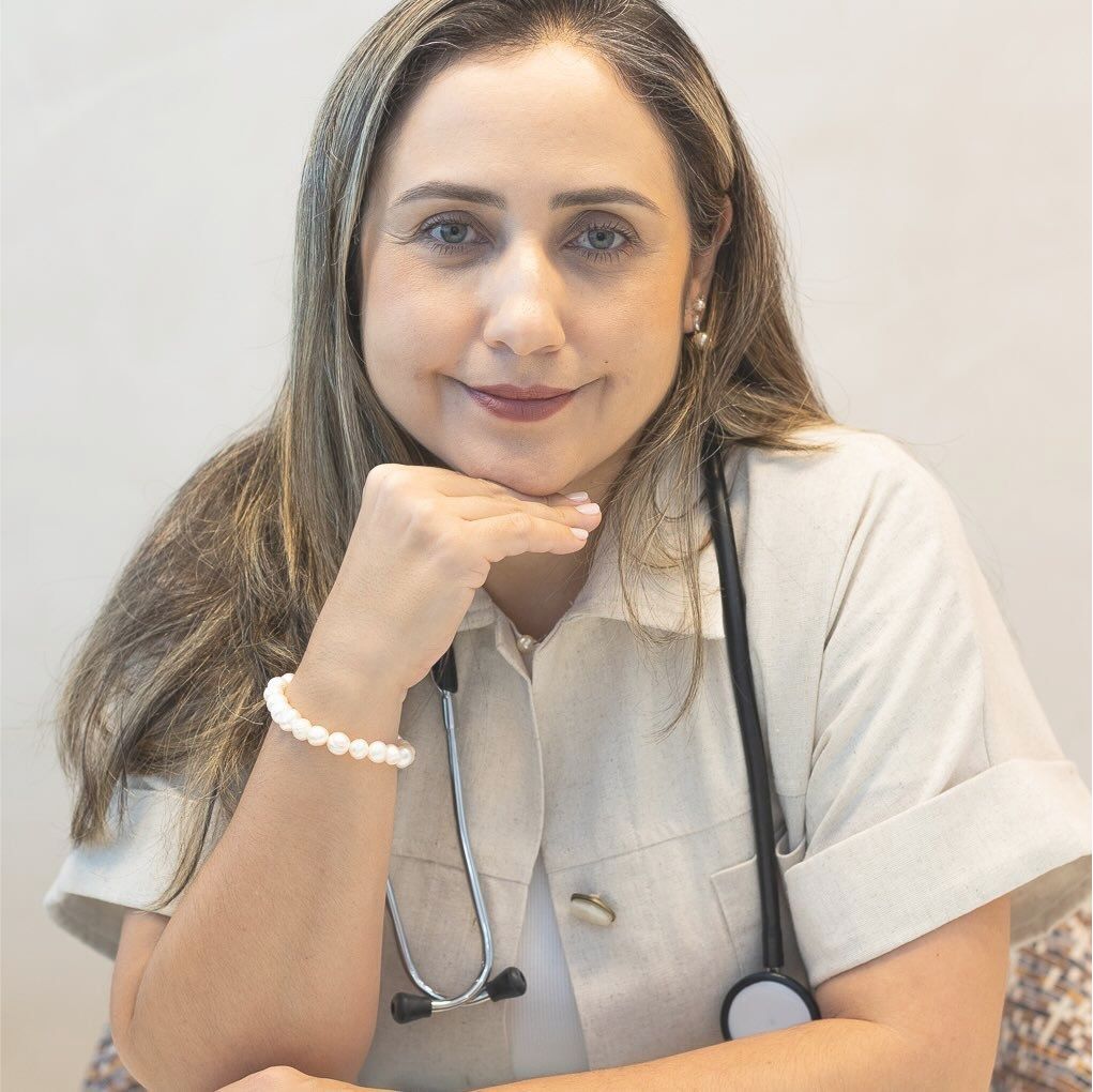 Dra. Grazielle Faria, médica endocrinologista, sorrindo com estetoscópio